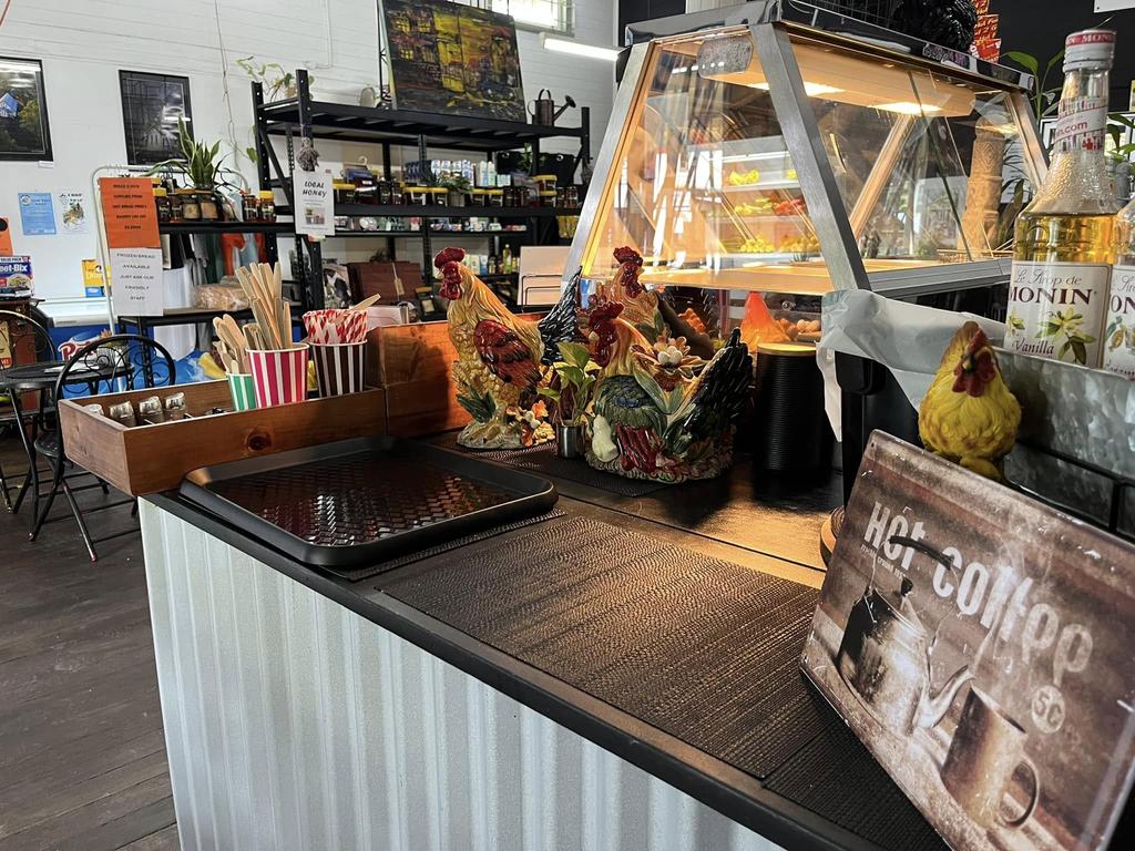 Front counter at Mount Perry General Store with flowers and baked goods.